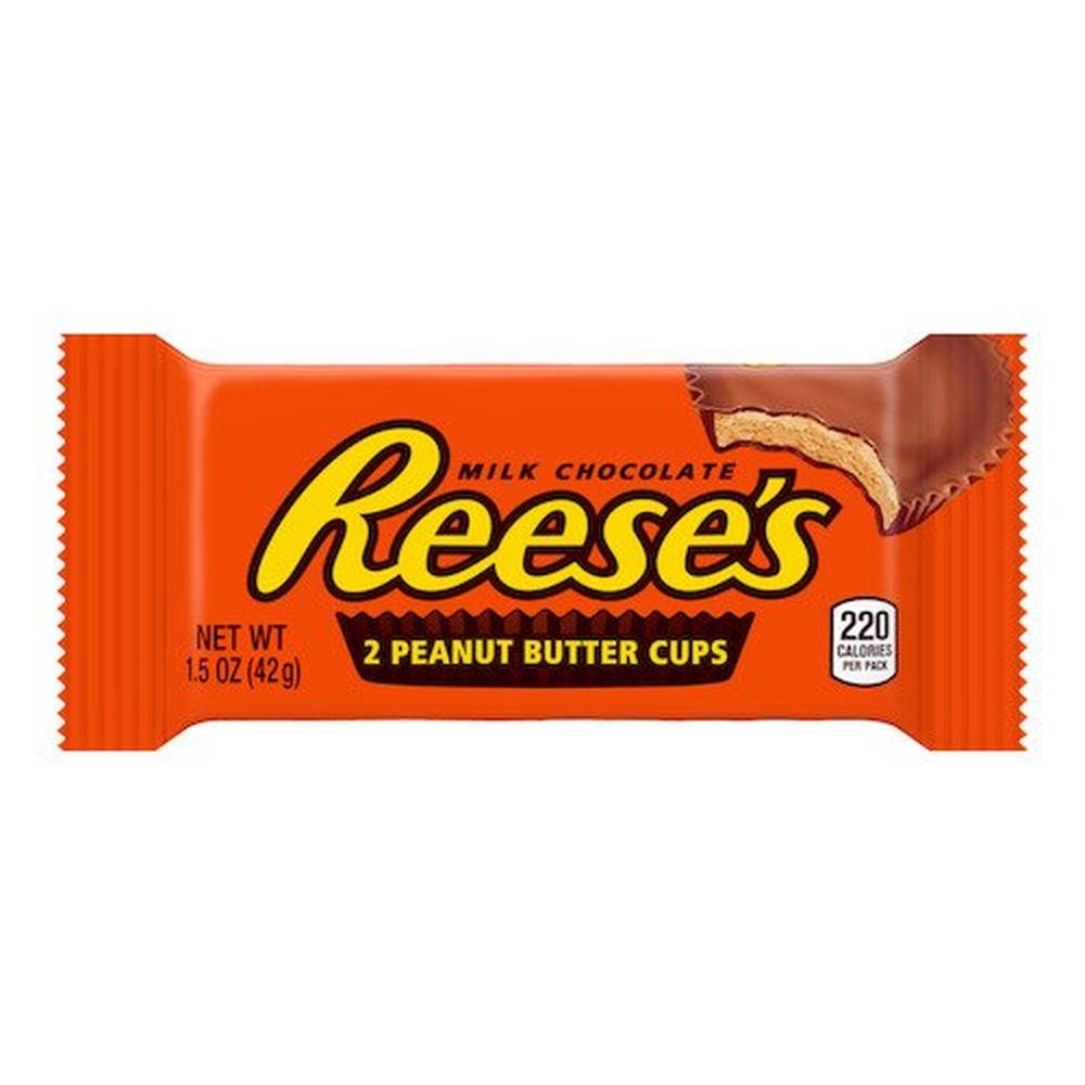 Un emballage orange sur fond blanc avec écrit « Reese’s » au centre et au milieu, au-dessus à droite il y a un chocolat en cup qui est croqué et on y voit une pâte brune claire