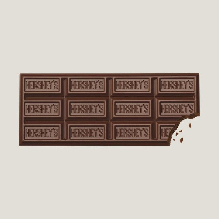 Une tablette de chocolat au lait sur fond blanc avec des inscriptions « Hershey’s » sur chaque carré, en bas à droite il y a un morceau qui a été croqué
