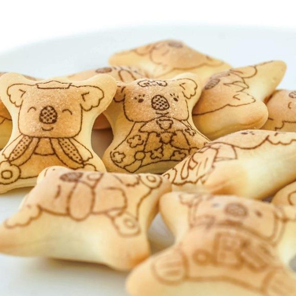 Plusieurs petits biscuits sur une table blanche avec des koalas dessinés sur chacun