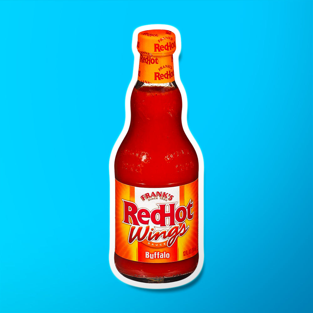 Une bouteille transparente avec une sauce rouge sur fond bleu et une étiquette rouge et jaune avec écrit « RedHot Wings » en grand