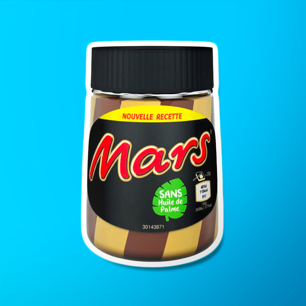 Un bocal en verre rempli de chocolat blanc et au lait, un couvercle noir et une étiquette noire avec écrit « Mars » en rouge. Le tout sur fond bleu