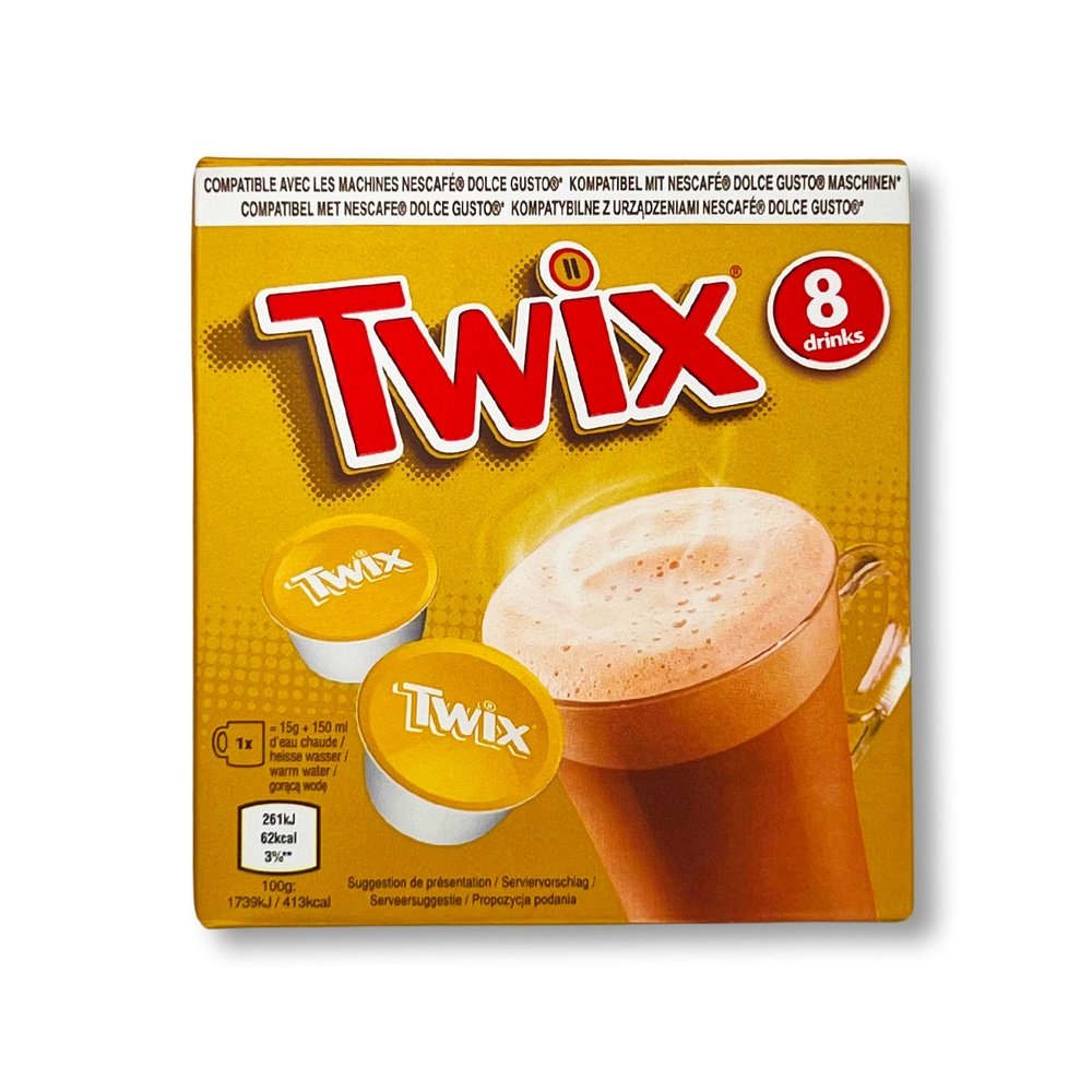 Un carton doré sur fond blanc avec une grande tasse transparente avec du chocolat chaud et à gauche 2 capsules blanches et jaunes