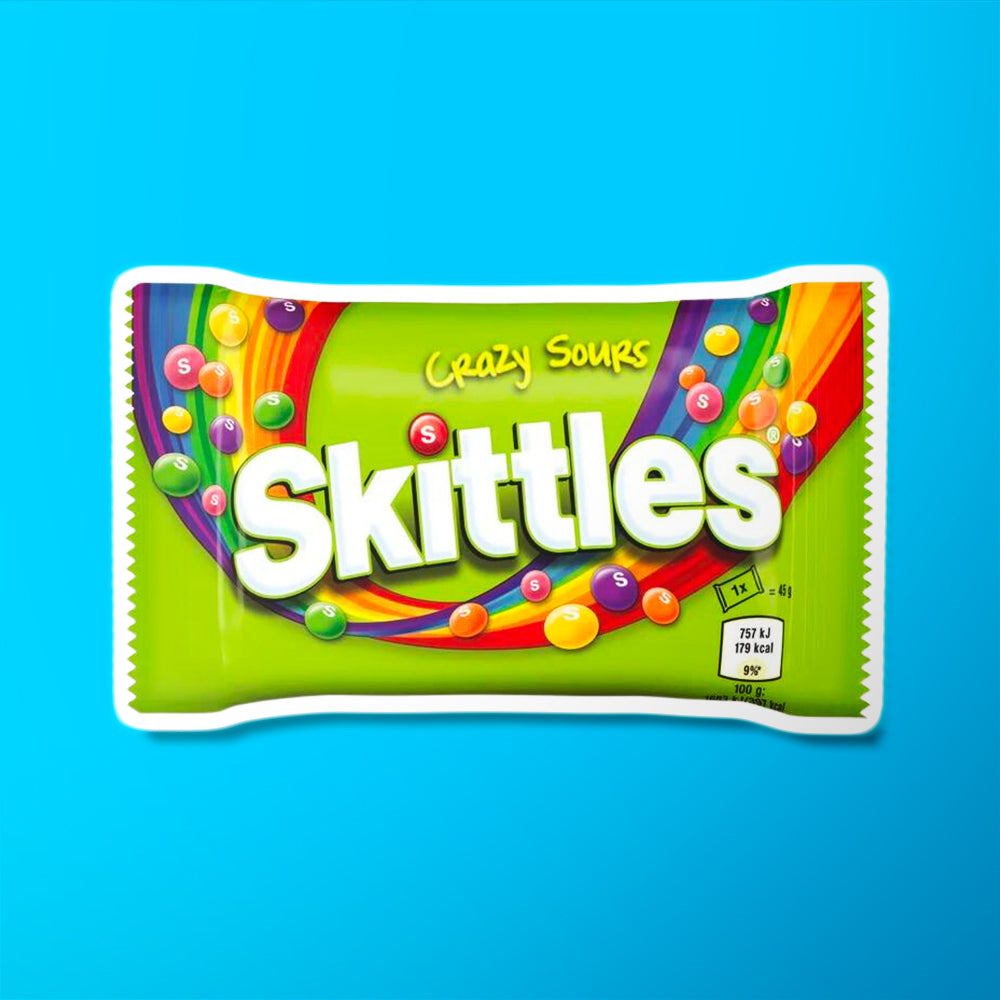 Un emballage vert sur fond bleu avec un arc-en-ciel qui le traverse et plein de petits Skittles dans l’air 