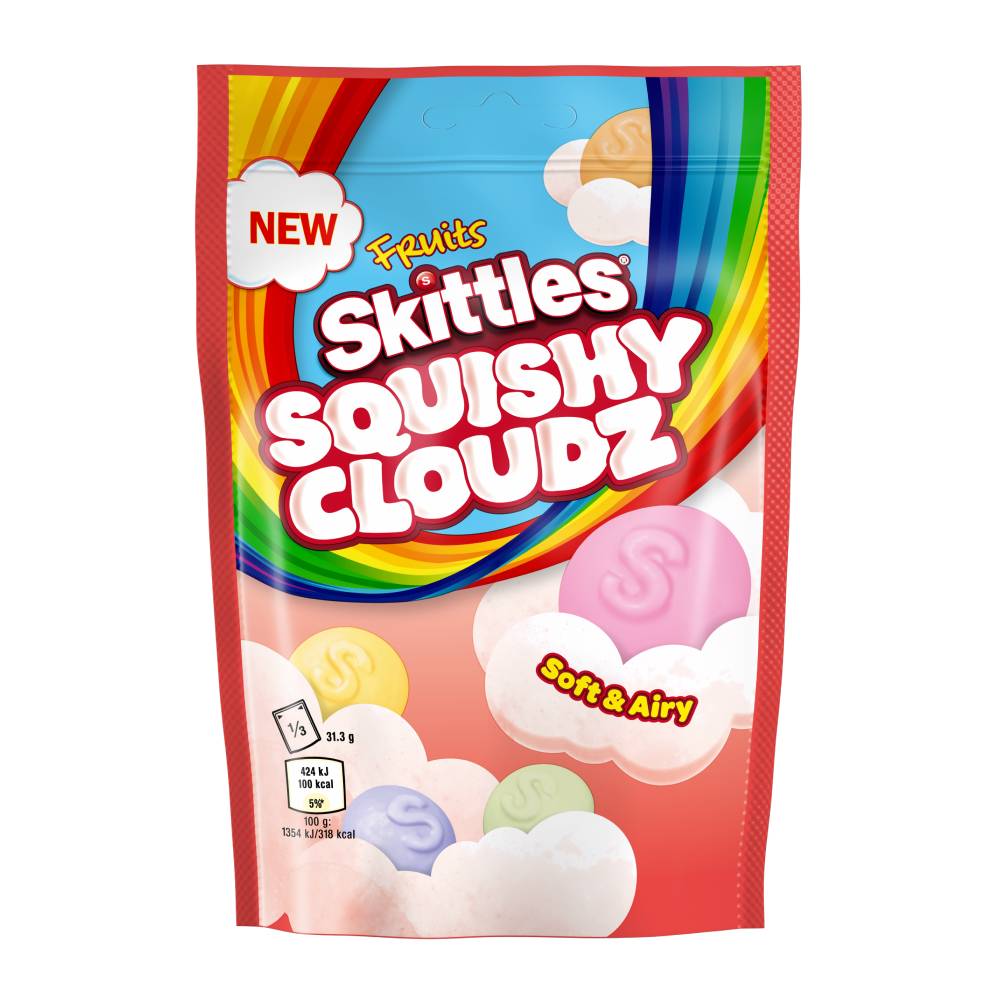 Un emballage rouge sur fond blanc avec un arc-en-ciel et des Skittles colorés sur des nuages roses pâles