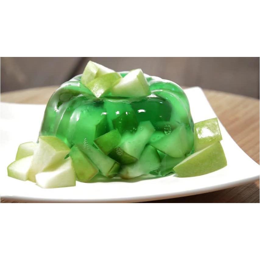 Une assiette avec de la gelée de pomme verte, et autour plusieurs petits morceaux de pommes vertes