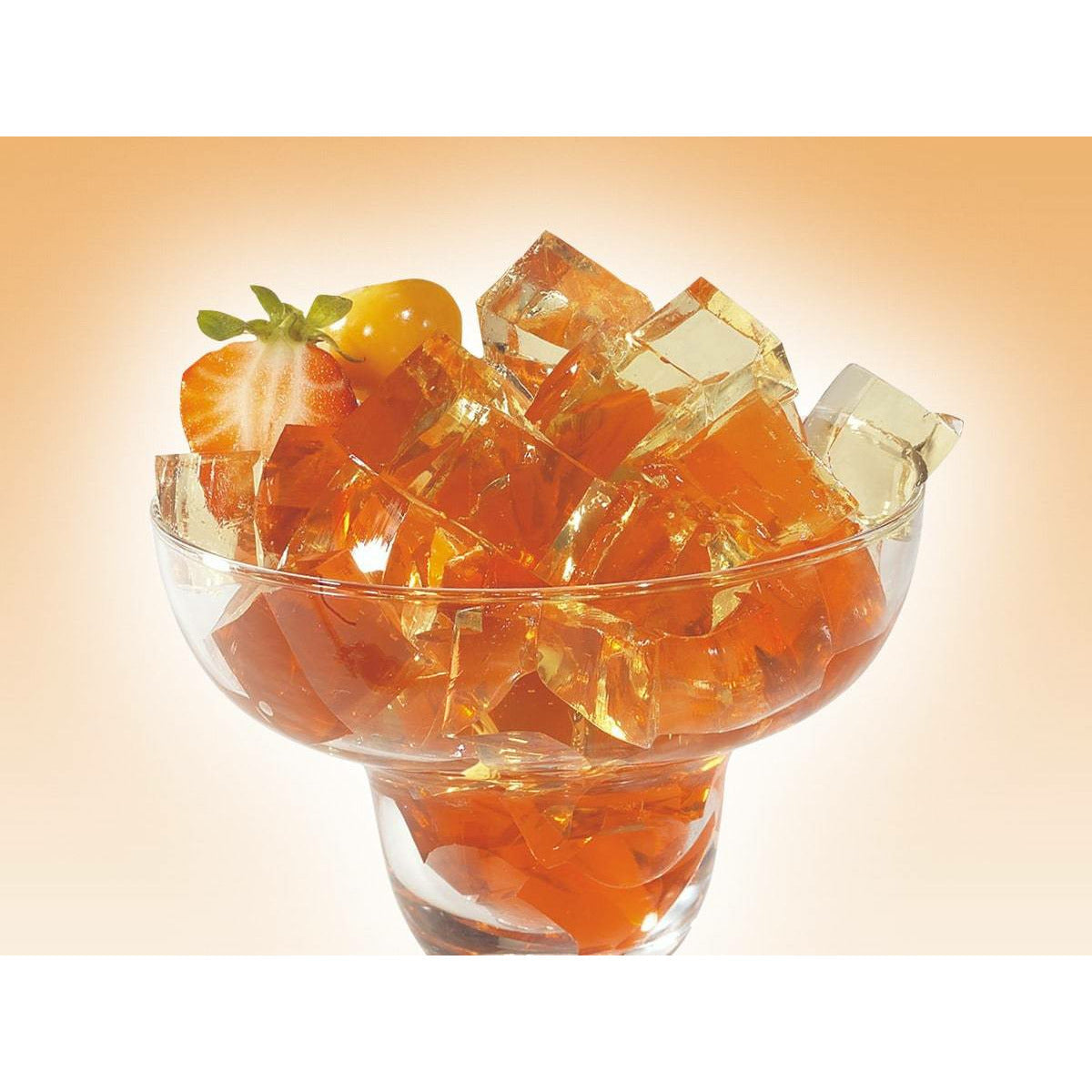 Un verre à cocktails transparent rempli de carré de gelée orange, sur un fond orangé