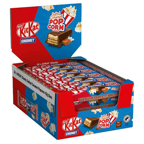 Un paquet en carton rouge et bleu sur fond blanc, il est rempli d’emballage avec une barre chocolaté en biscuit et des popcorns 