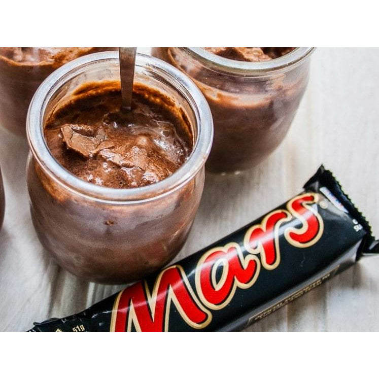 Des petits pots rempli de chocolat et devant un emballage noir avec écrit « Mars » en rouge, le tout sur une table en bois