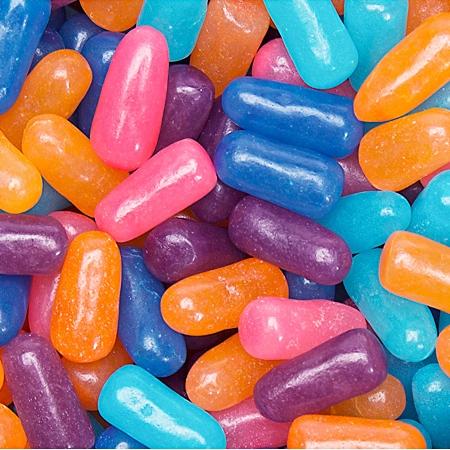 Des bonbons en formes de pilules mauve, rose, orange et bleu