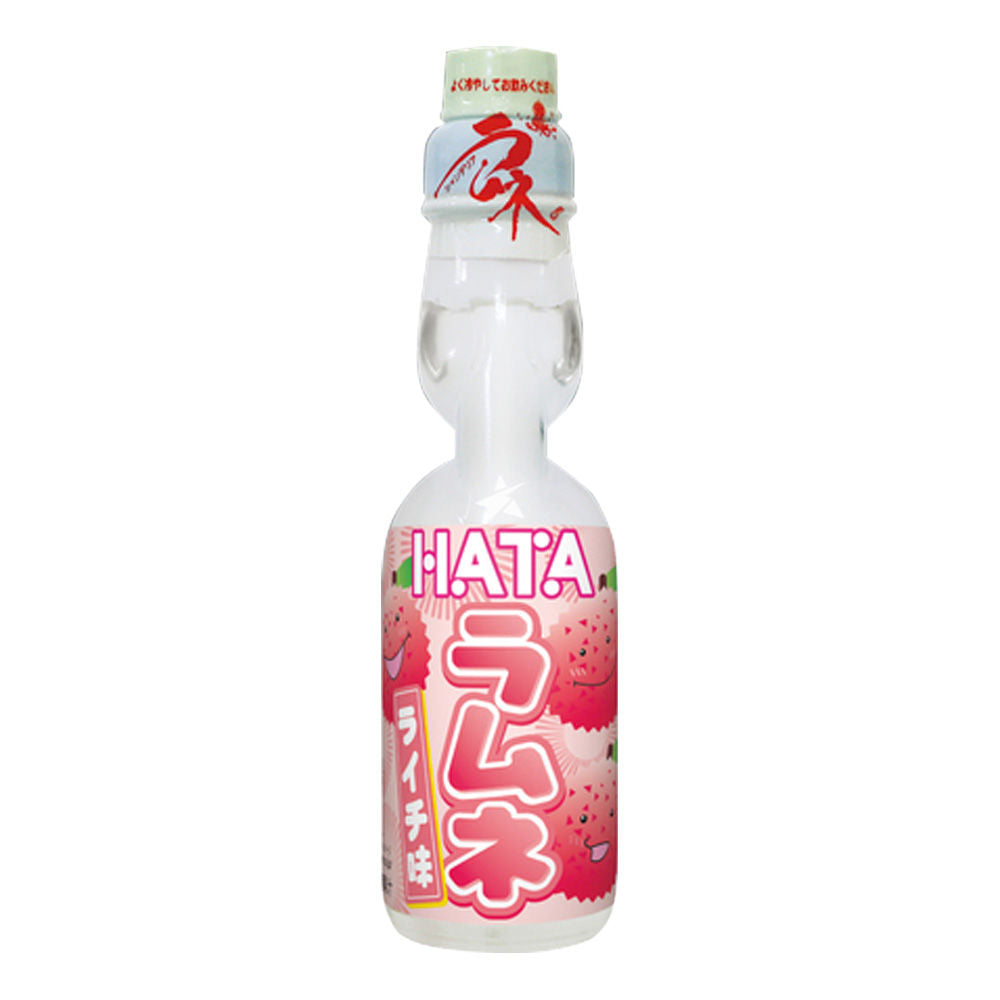 Une bouteille transparente sur fond blanc avec une boisson légèrement blanche, il y a une étiquette rose sur la moitié basse de la bouteille. Il y a des litchis qui sourient
