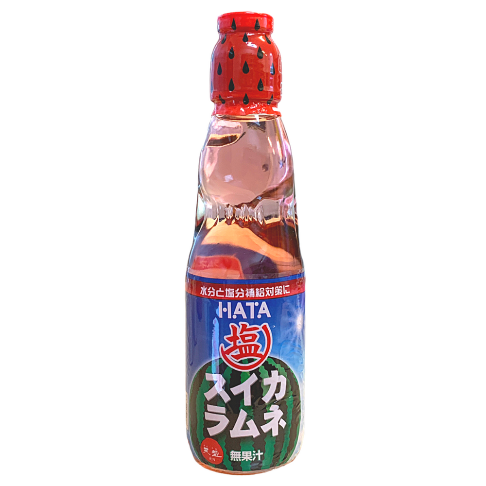 Une bouteille transparente sur fond blanc avec une boisson légèrement rosée, il y a une étiquette bleu sur la moitié basse de la bouteille avec une grande pastèque au centre